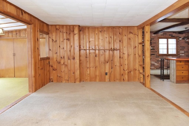 carpeted empty room featuring wooden walls