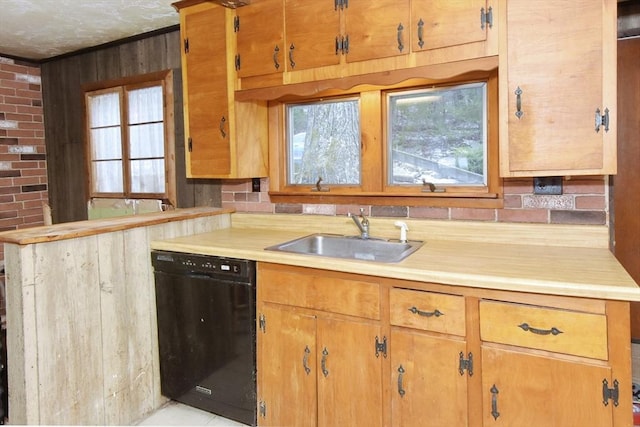 kitchen featuring kitchen peninsula, wooden walls, sink, light tile patterned floors, and dishwasher