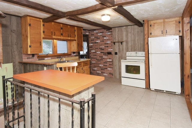 kitchen featuring kitchen peninsula, beamed ceiling, and white appliances