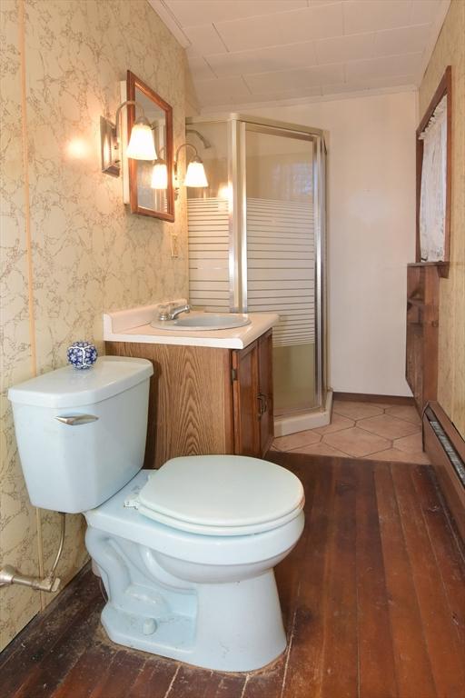 bathroom with vanity, toilet, an enclosed shower, and vaulted ceiling