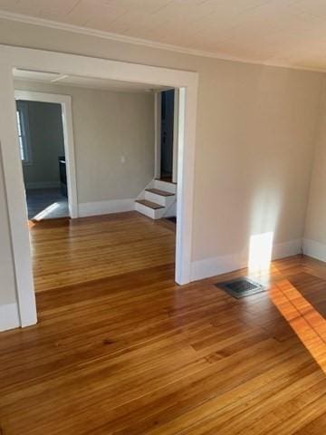 spare room featuring hardwood / wood-style floors and crown molding