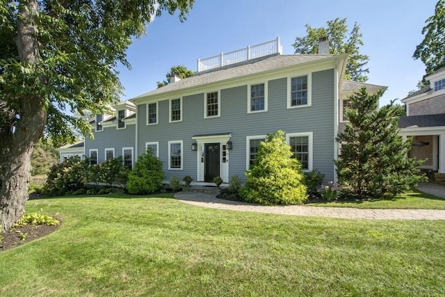 colonial-style house with a front lawn