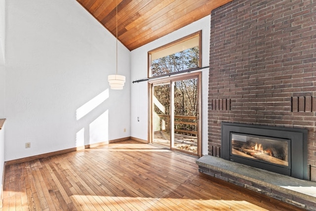 unfurnished living room with hardwood / wood-style floors, wooden ceiling, a fireplace, and high vaulted ceiling