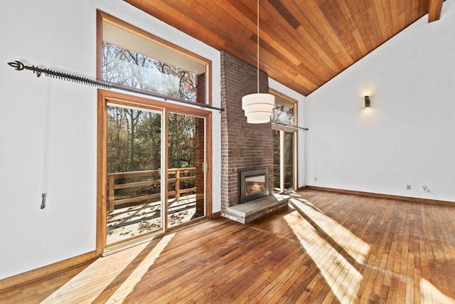 unfurnished living room with hardwood / wood-style flooring, wooden ceiling, high vaulted ceiling, and a brick fireplace