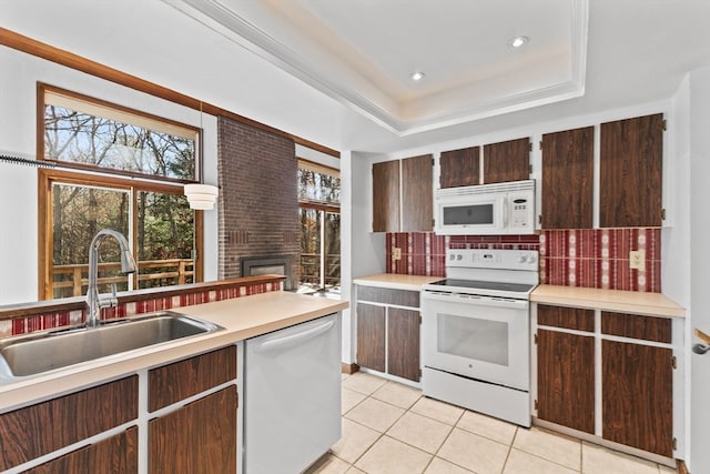 kitchen with white appliances, a raised ceiling, sink, decorative backsplash, and light tile patterned floors