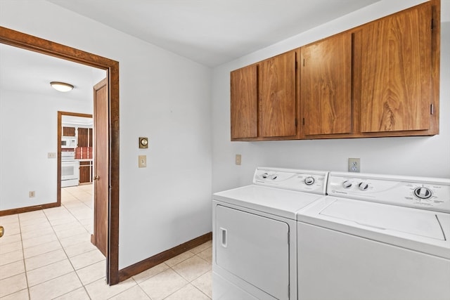 laundry area with cabinets, light tile patterned floors, and separate washer and dryer