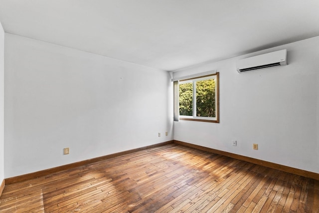 empty room with a wall unit AC and wood-type flooring