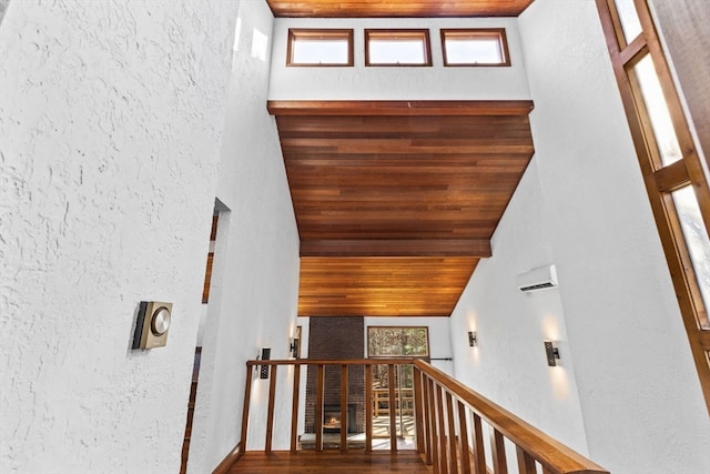 staircase with hardwood / wood-style floors, wooden ceiling, and high vaulted ceiling