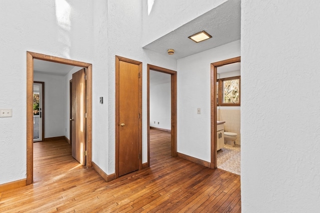 hall with hardwood / wood-style flooring and a textured ceiling