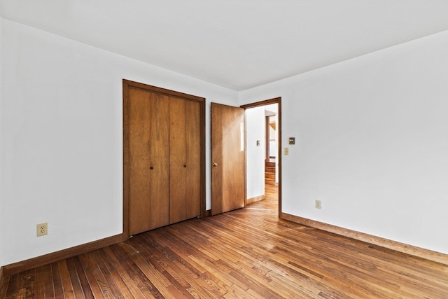 unfurnished bedroom with a closet and light hardwood / wood-style floors