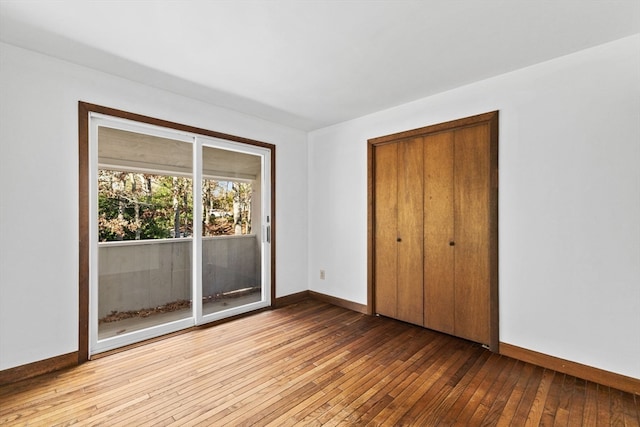 unfurnished bedroom with access to exterior, light hardwood / wood-style flooring, and a closet