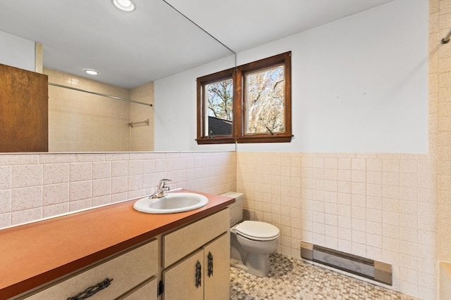 bathroom featuring vanity, tile walls, and toilet