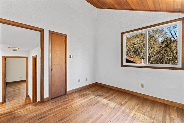 empty room with light hardwood / wood-style flooring, lofted ceiling, and wood ceiling