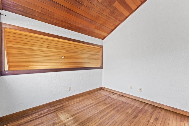 unfurnished room with wood-type flooring, lofted ceiling, and wood ceiling