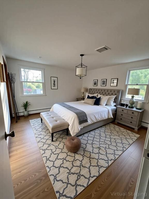 21 Friends Ln, Dennis, MA 02660 - bedroom with multiple windows, light wood finished floors, and a baseboard radiator