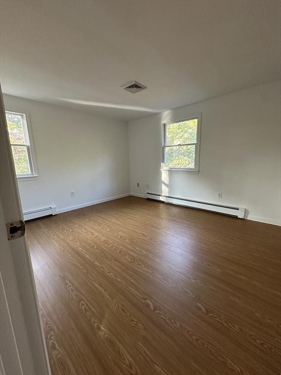 21 Friends Ln, Dennis, MA 02660 - spare room featuring baseboard heating, a baseboard heating unit, dark wood finished floors, and healthy amount of natural light