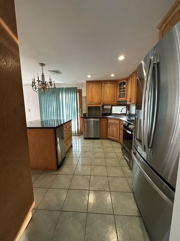 21 Friends Ln, Dennis, MA 02660 - kitchen with appliances with stainless steel finishes, dark countertops, brown cabinets, a chandelier, and recessed lighting