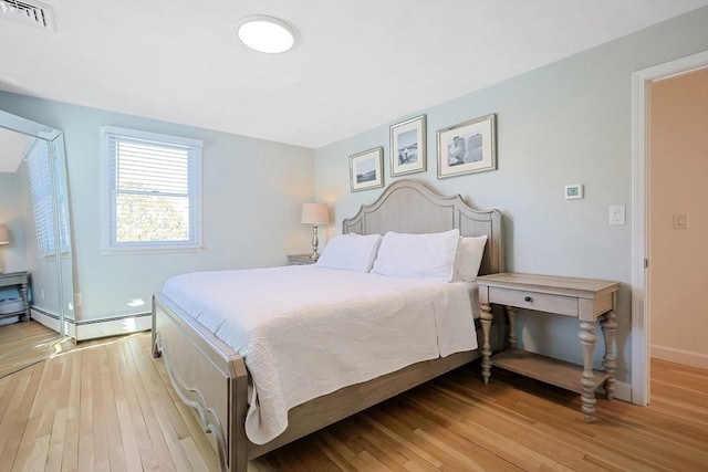 bedroom featuring baseboards, visible vents, and light wood-style floors