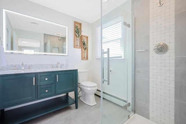 full bathroom with toilet, a sink, baseboard heating, double vanity, and a stall shower