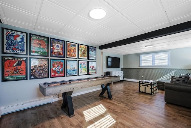 game room with a wainscoted wall, baseboards, baseboard heating, and wood finished floors