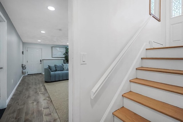 stairway with recessed lighting, wood finished floors, and baseboards