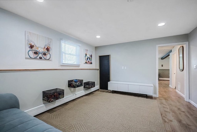 living area featuring recessed lighting, baseboard heating, baseboards, and wood finished floors