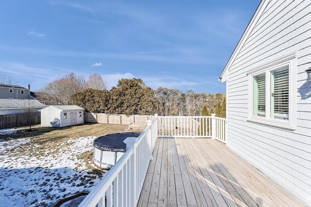 deck with an outbuilding, a storage unit, and a fenced backyard