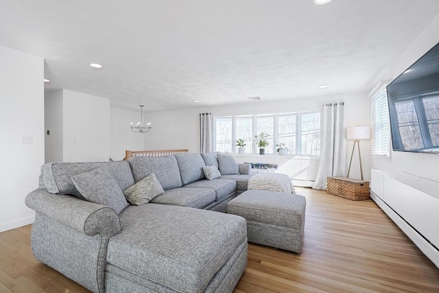 living area featuring a baseboard heating unit, light wood-type flooring, a wealth of natural light, and recessed lighting