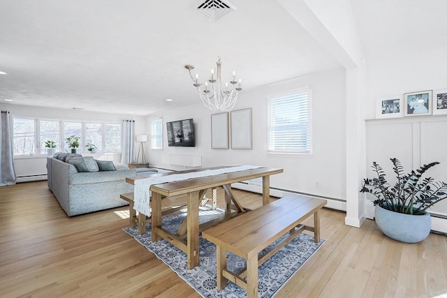 dining space with light wood-style floors, a baseboard radiator, visible vents, and an inviting chandelier