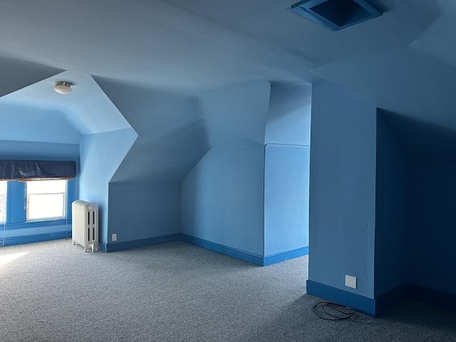 bonus room featuring light colored carpet, radiator heating unit, and vaulted ceiling