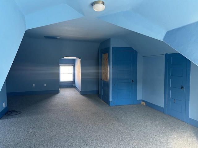 additional living space featuring lofted ceiling and carpet floors