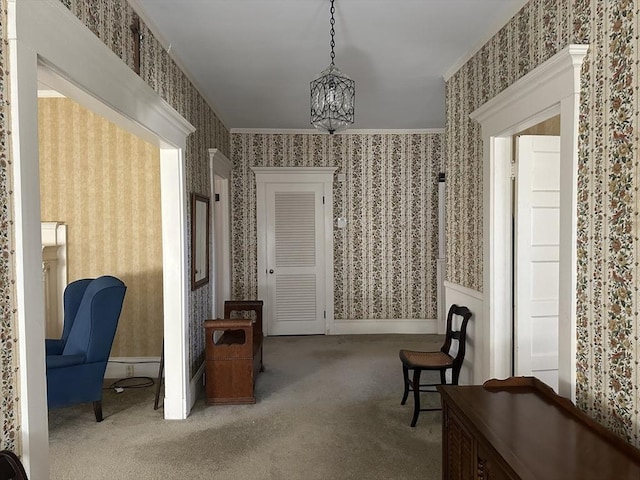 living area featuring crown molding, carpet flooring, and an inviting chandelier