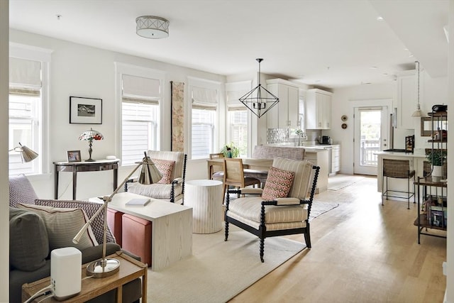 living room featuring a notable chandelier and light hardwood / wood-style floors