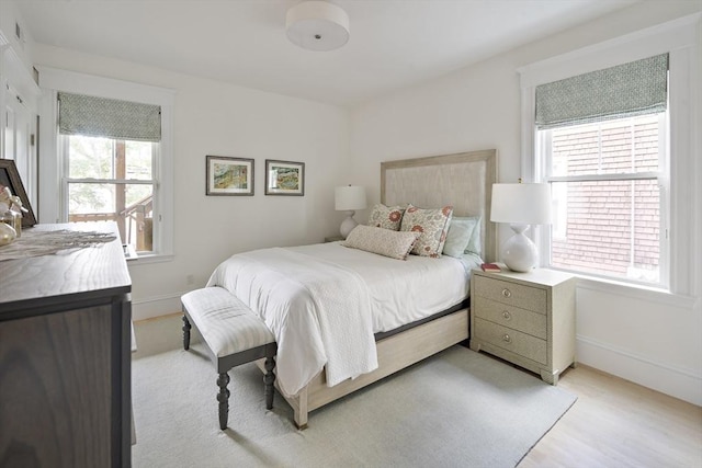 bedroom with multiple windows and light hardwood / wood-style flooring