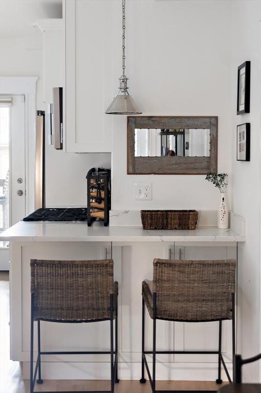 kitchen featuring a breakfast bar area and white cabinets