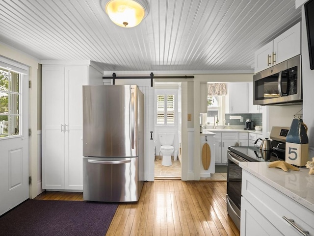 5 Adams St, Littleton, MA 01460 - kitchen with stainless steel appliances, plenty of natural light, light countertops, and white cabinetry