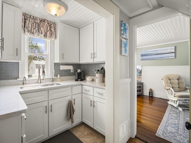 5 Adams St, Littleton, MA 01460 - kitchen featuring a sink, a wainscoted wall, white cabinetry, light countertops, and backsplash