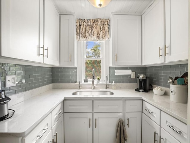 5 Adams St, Littleton, MA 01460 - kitchen with a sink, white cabinetry, light stone countertops, and tasteful backsplash