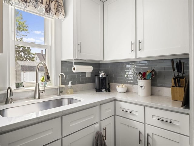 5 Adams St, Littleton, MA 01460 - kitchen featuring a sink, white cabinetry, tasteful backsplash, and light stone counters