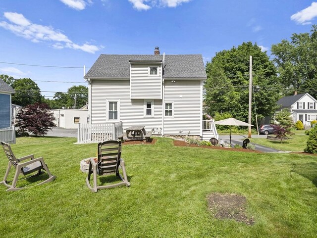 5 Adams St, Littleton, MA 01460 - rear view of property featuring roof with shingles, a chimney, and a lawn
