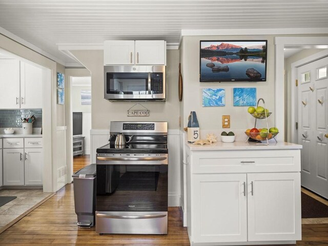 5 Adams St, Littleton, MA 01460 - kitchen featuring stainless steel appliances, wood finished floors, white cabinetry, tasteful backsplash, and light countertops