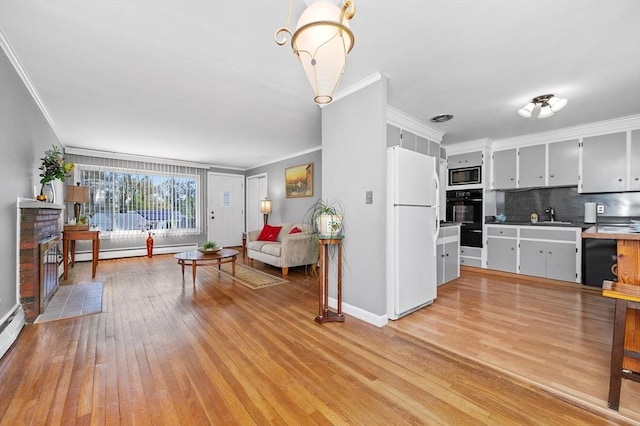 living area with a fireplace with flush hearth, baseboards, a baseboard heating unit, ornamental molding, and light wood-style flooring