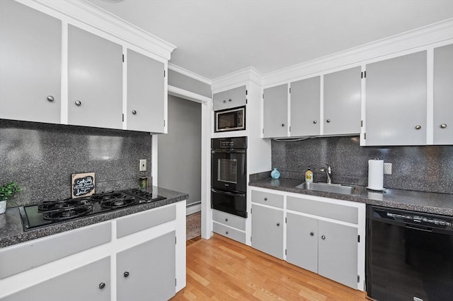 kitchen with a sink, a warming drawer, black appliances, and tasteful backsplash