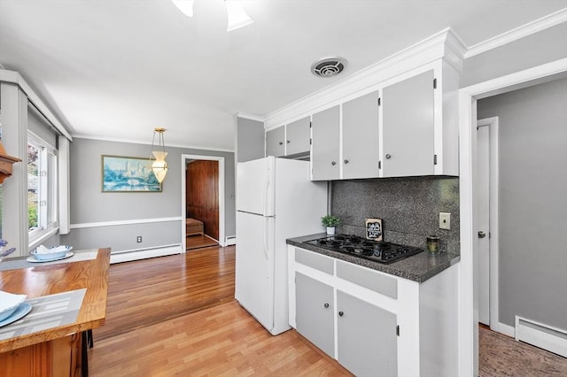 kitchen featuring freestanding refrigerator, dark countertops, black stovetop, and baseboard heating
