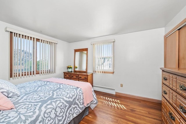 bedroom featuring a baseboard radiator, a closet, and wood finished floors