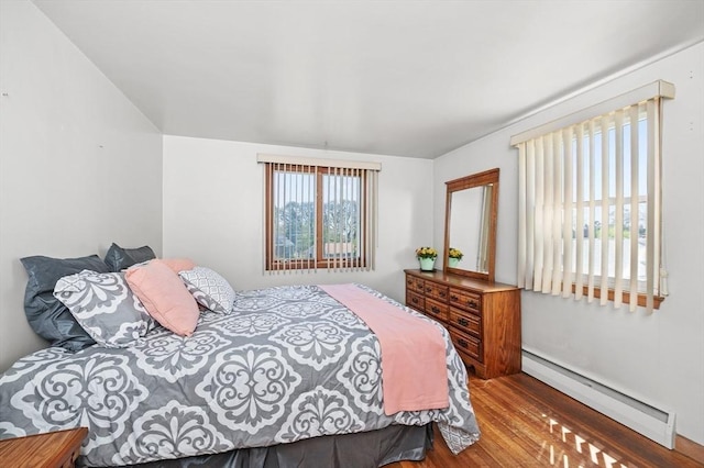 bedroom featuring baseboard heating and wood finished floors