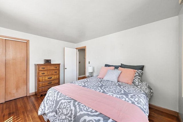 bedroom with baseboards, wood finished floors, and a closet