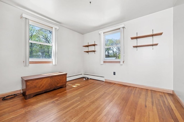 unfurnished room featuring baseboards, plenty of natural light, and light wood finished floors