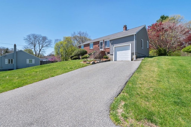 ranch-style home featuring an attached garage, a front yard, driveway, and a chimney
