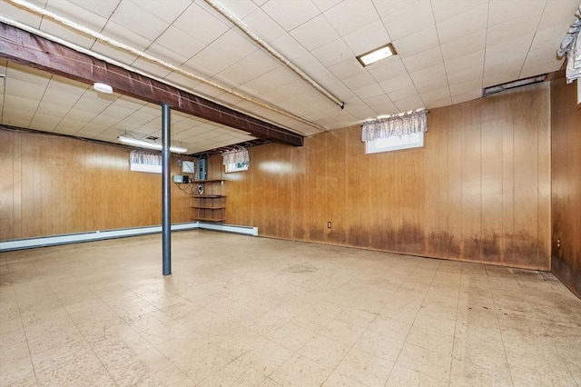 below grade area featuring wood walls, tile patterned floors, and baseboard heating